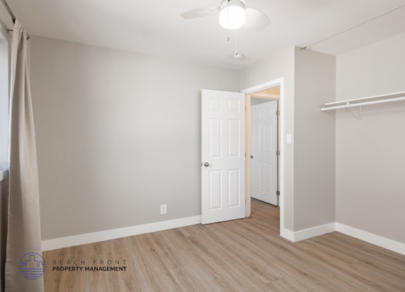 A room with a door and a wall with a shelf.