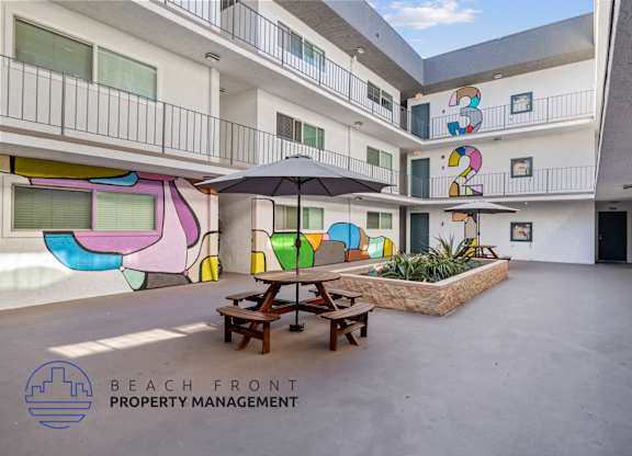 A courtyard with a picnic table and a mural on the wall.