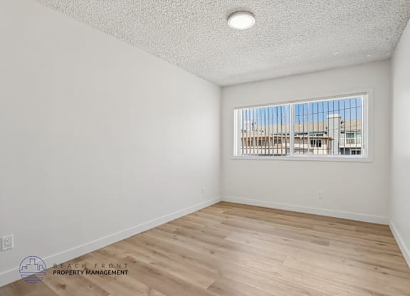 A room with a window overlooking a building.