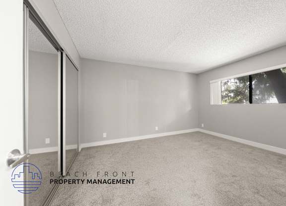 the spacious living room of a manufactured home with carpet and a large window