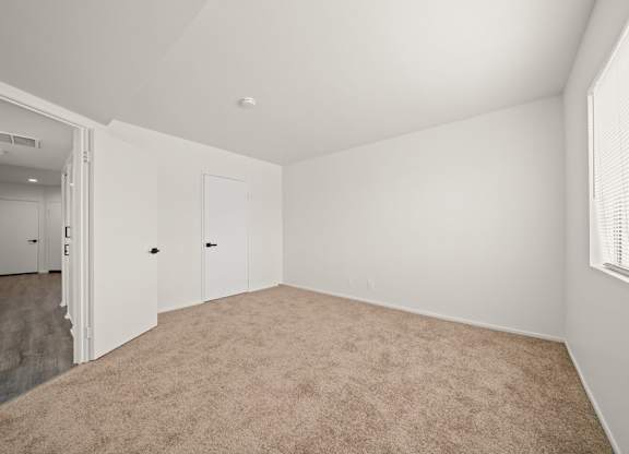 A room with carpeted floor and white walls.