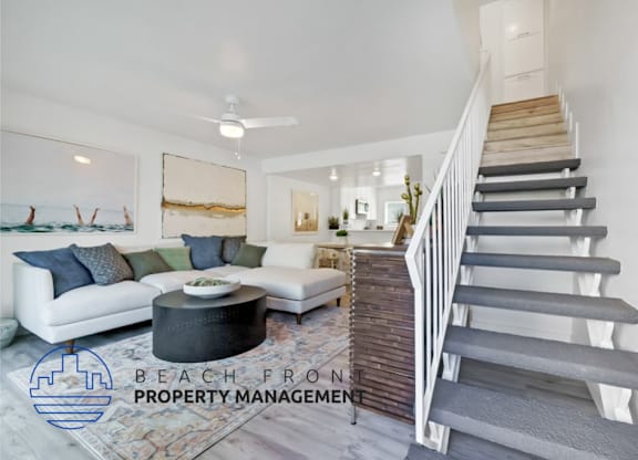 an image of a living room with a staircase and a couch
