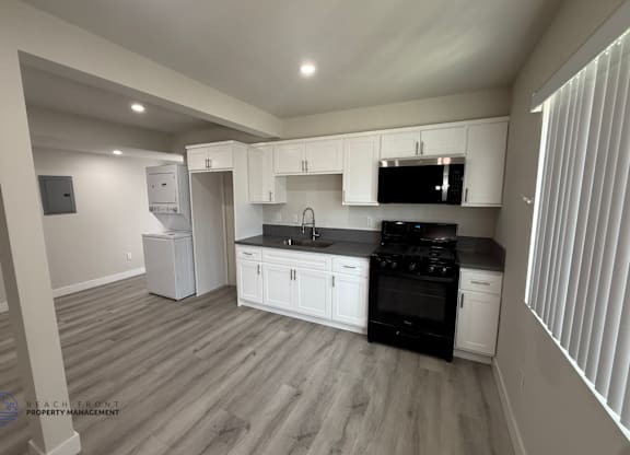 A spacious room with a ceiling fan and wooden flooring.