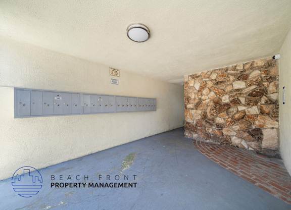 A room with a stone wall and a row of lockers.