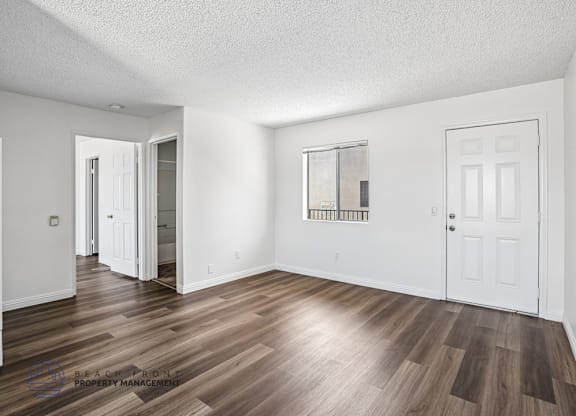 A room with wooden flooring and white walls.