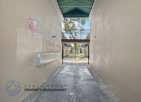 A narrow alley with a sign that says