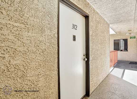 A door with the number 312 on it is in a hallway.