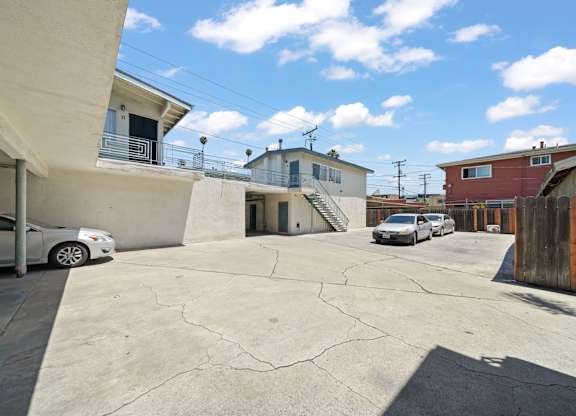 A white car is parked in a driveway.