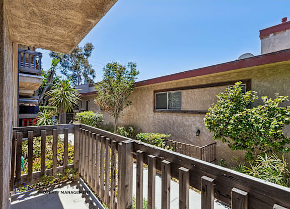 A balcony with a railing and plants on it.
