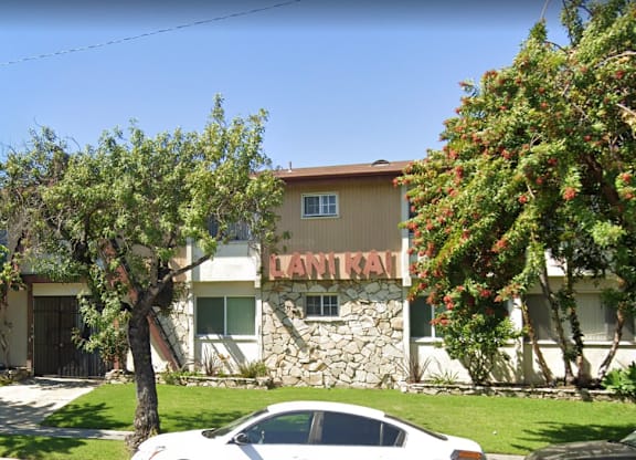 A car is parked in front of a building with the word