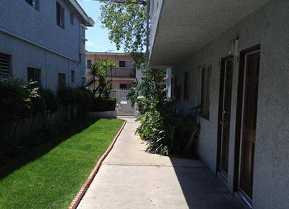 A long concrete walkway leads between two buildings.