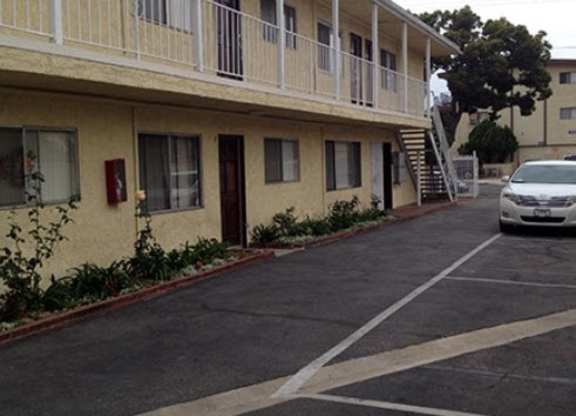 A car is parked in a parking lot in front of a building.