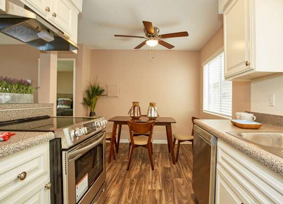 a kitchen with a table and chairs and a ceiling fan