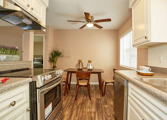 a kitchen with a table and chairs and a ceiling fan