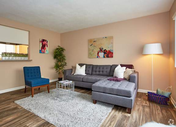 a living room with a gray couch and a blue chair