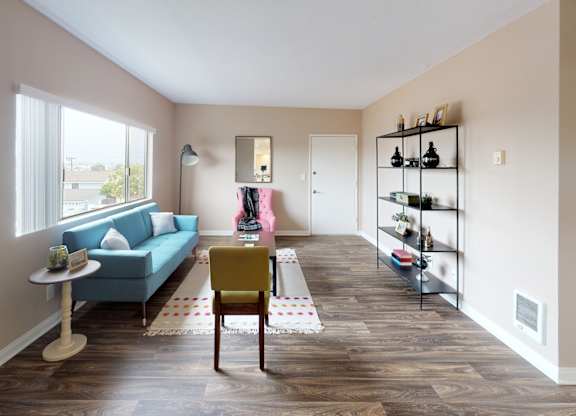 a living room with a blue couch and a table with a yellow chair