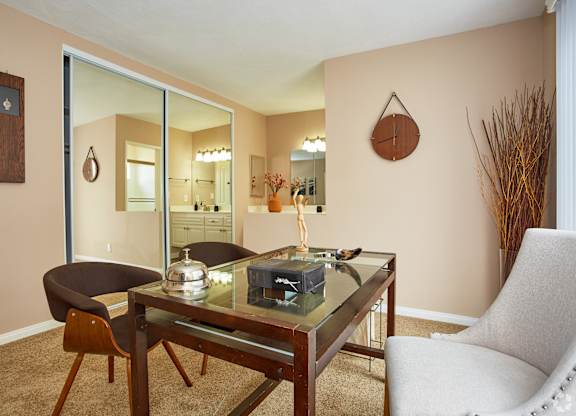 a living room with a glass table and two chairs