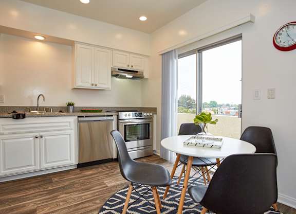 a kitchen with white cabinets and a large window