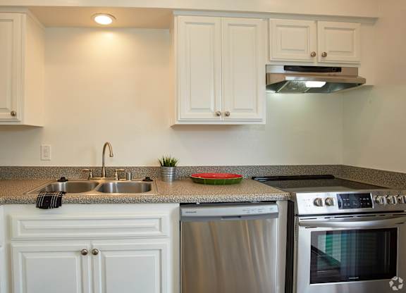 a kitchen with white cabinets and stainless steel appliances