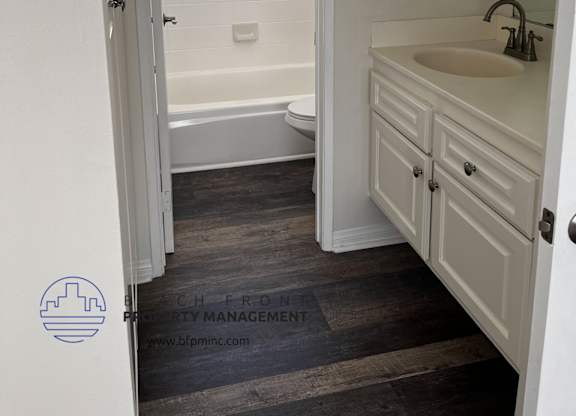 a bedroom with a medium sized bathroom with a bathtub and a sink