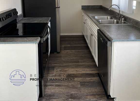 a kitchen with white cabinets and black appliances