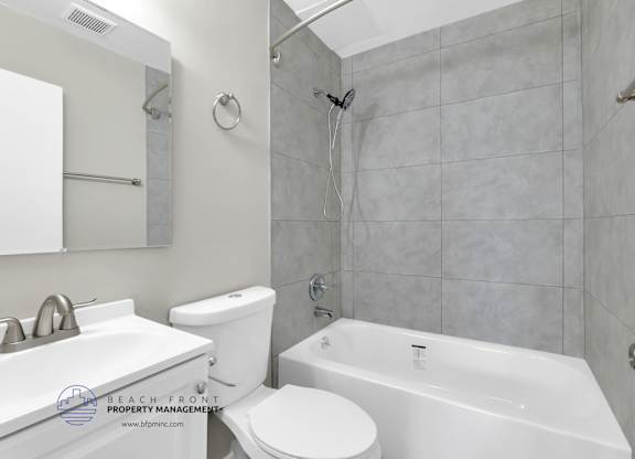 A white bathroom with a toilet, sink, and bathtub.