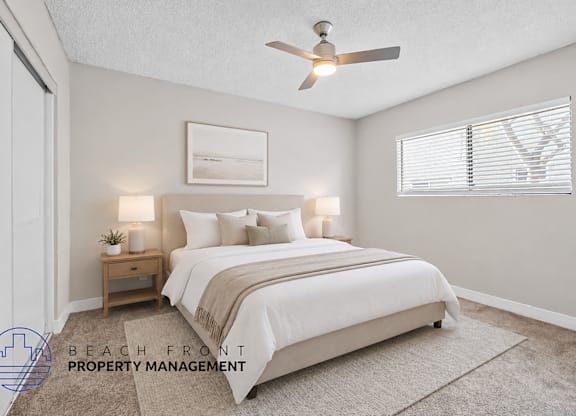 A bedroom with a bed, nightstand, and a ceiling fan.