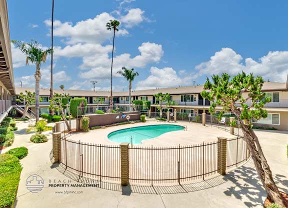 A pool surrounded by a fence with the words Beach Property Management on it.