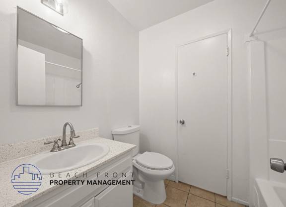 A white bathroom with a sink, toilet, and bathtub.