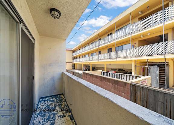 A balcony with a view of a building and a blue sky.