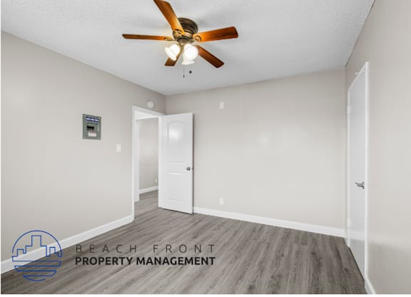 an empty room with a ceiling fan and a door