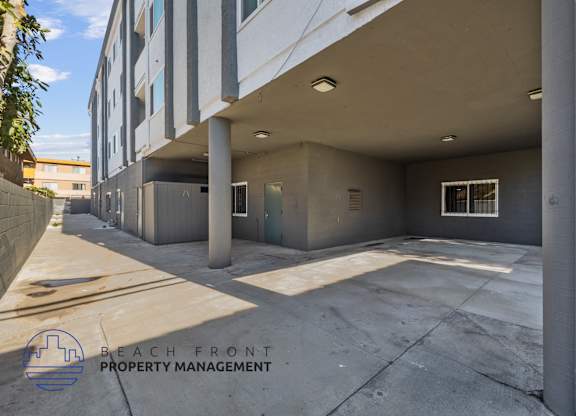 A parking garage with a logo for Beach Front Property Management.