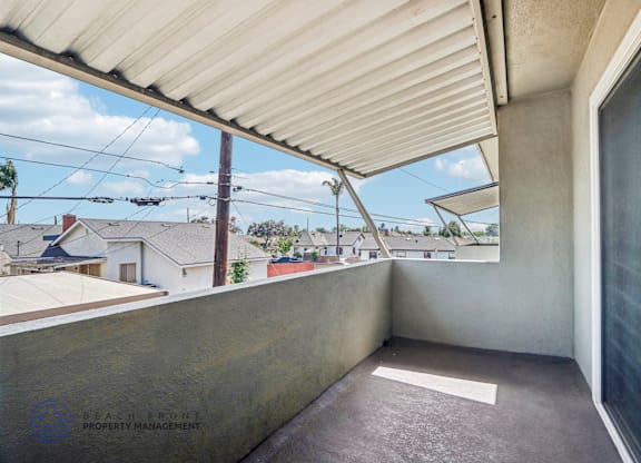 A balcony with a view of houses and trees.