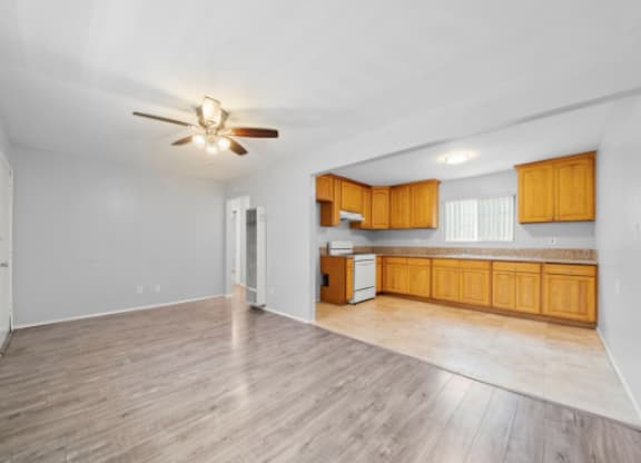 A room with a ceiling fan and wooden flooring.