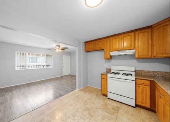 A kitchen with a white oven and wooden cabinets.