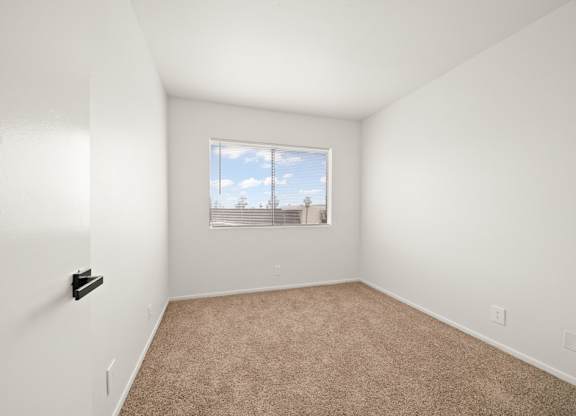 an empty room with carpet and a window