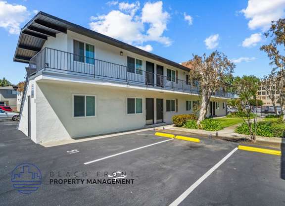 an apartment building with a parking lot and a balcony