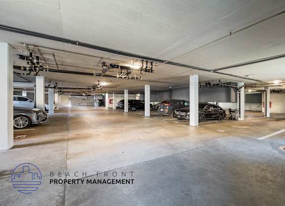 A spacious parking garage with multiple cars parked inside.
