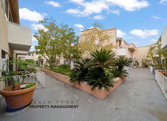 a courtyard with plants and apartments on both sides of a building