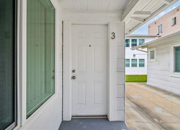 A white door with a number 3 on it is the entrance to a home.