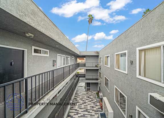 A balcony with a black railing and a tiled floor.