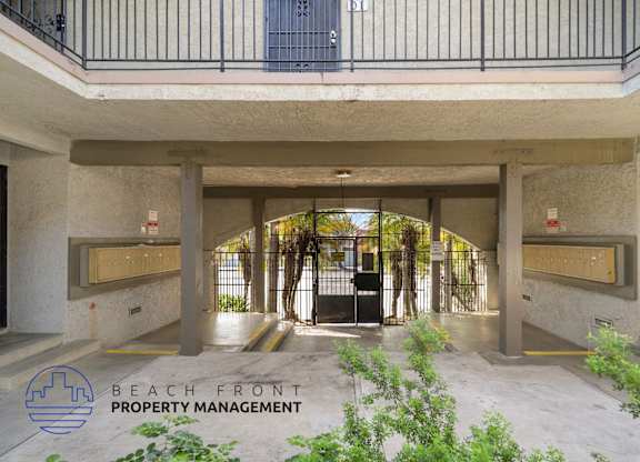 A building entrance with a sign that says Beach Front Property Management.