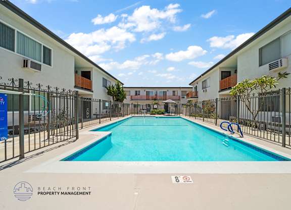 A swimming pool surrounded by a fence and buildings.