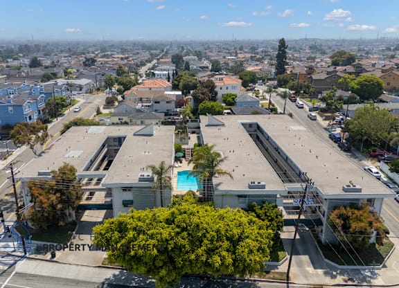 A bird's eye view of a city with buildings, roads, and a pool.