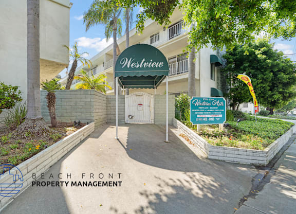 The entrance to a building named Westview with a sign for Beach Front Property Management.