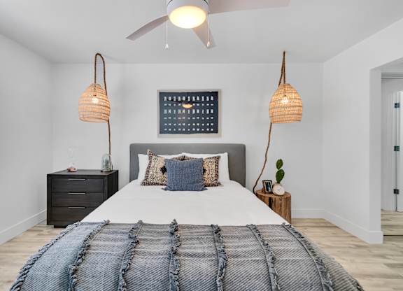 A bedroom with a large bed and a ceiling fan.