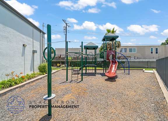 A playground with a slide and a green pole.