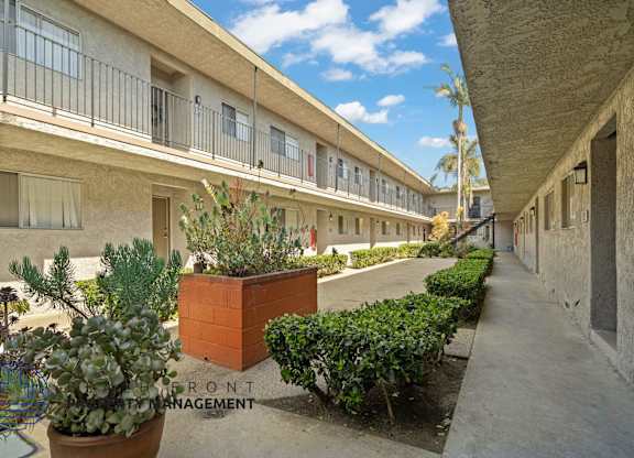 A courtyard with a brick planter and a sign that says Front Management.