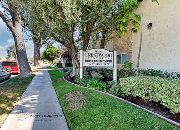 A sign for Crestwood Apartments is displayed in front of a building.