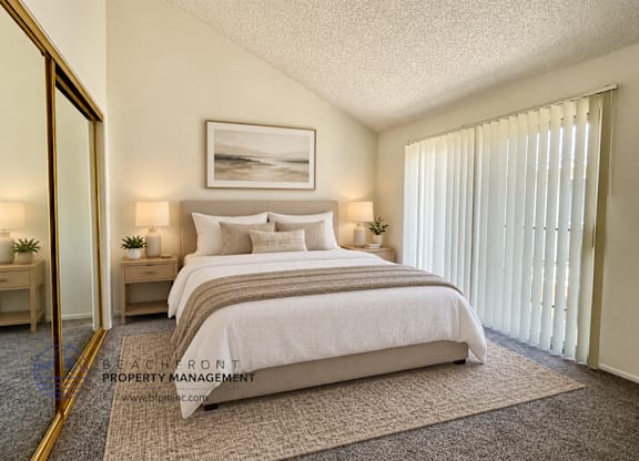 A bedroom with a large bed, a painting on the wall, and a carpet on the floor.